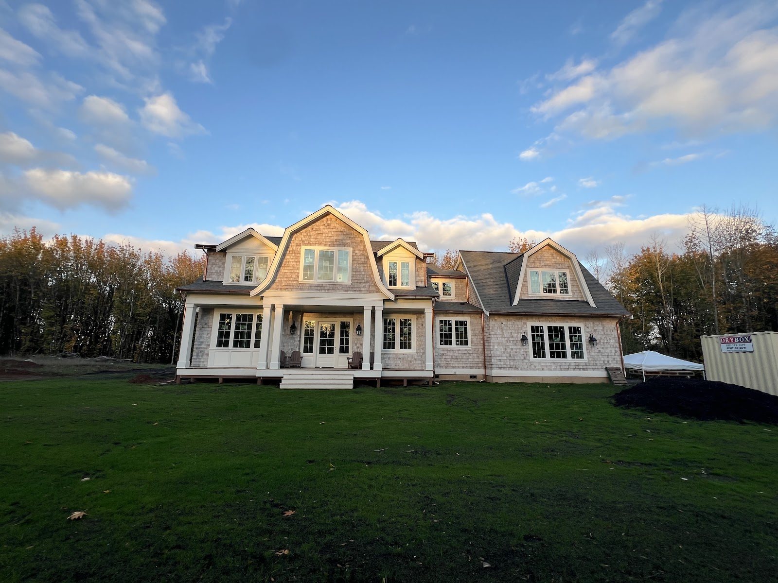 Full cedar-shake gambrel home at golden hour, sided and trimmed by O'Neil Custom Exteriors
